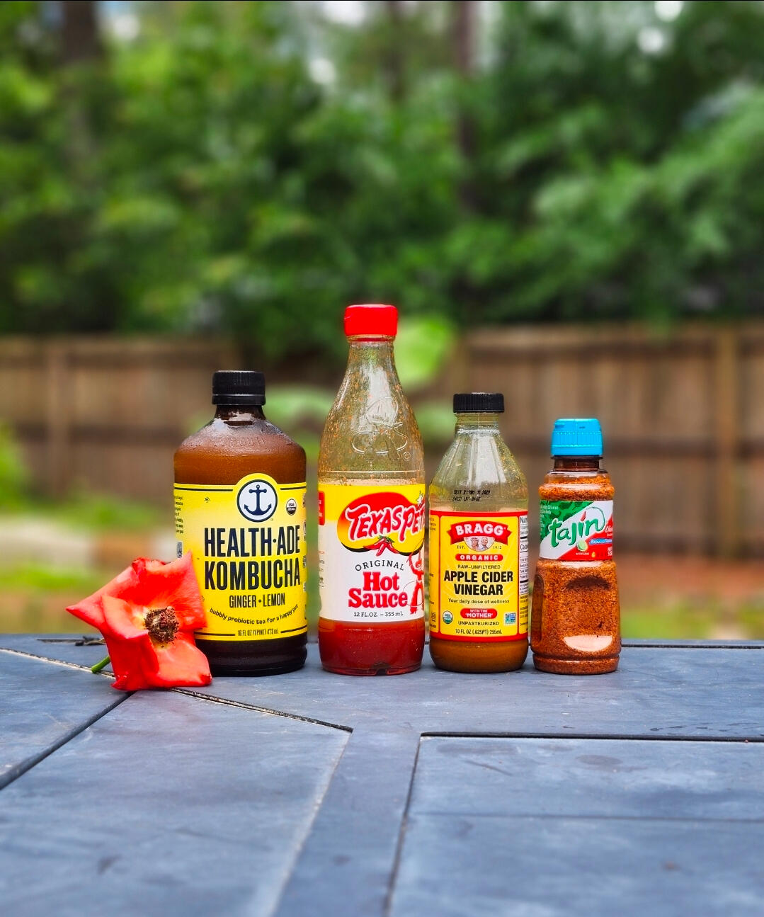 Commercial product photography featuring branded food and beverage products, including Tajín seasoning, Texas Pete hot sauce, Bragg apple cider vinegar, and kombucha, photographed by LuxeGrid Media